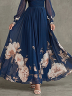Abito lungo elegante con maniche velate e orlo floreale